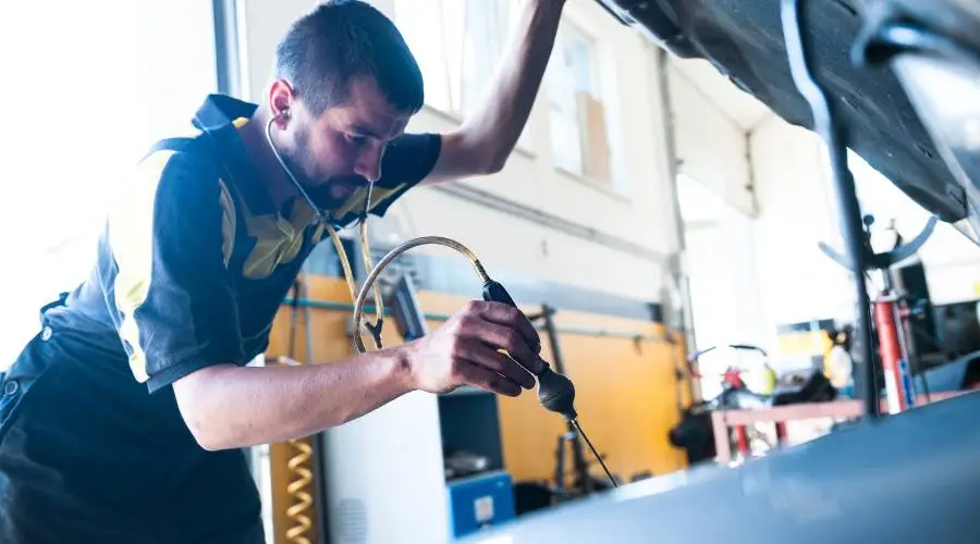 Professional mechanic diagnosing engine noise problems using automotive stethoscope diagnostic tools