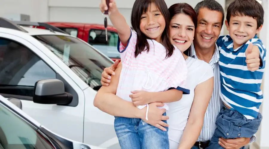 Happy family with newly purchased used car after professional pre-purchase inspection confident buying decision