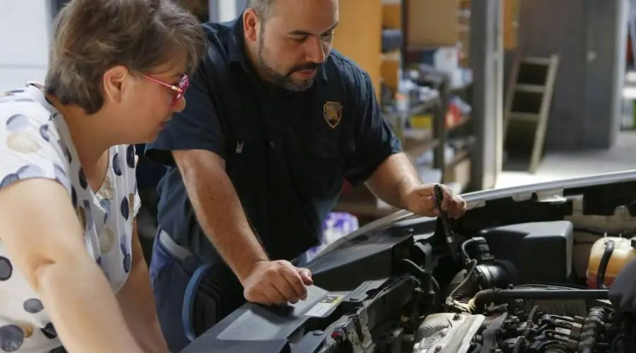 Professional mechanic explaining red flags warning signs used car inspection concerned buyer Queensland
