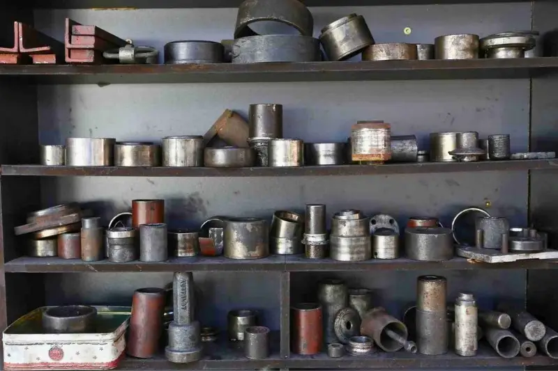 Assorted metal components on a shelf.