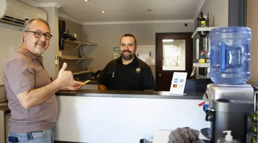 Two men smiling at office reception desk.